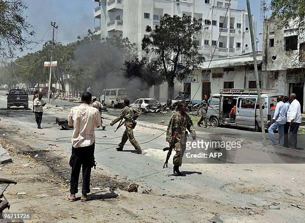 Somali soldiers and civilians walk around the scene of an explosion in Mogadishu on February 15, 2010. Somali State Minister of Defence, Yusuf...