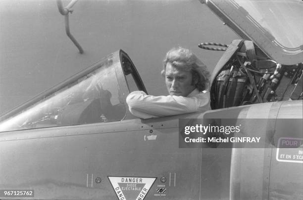 Johnny Hallyday pose dans un avion de chasse sur le porte-avions 'Clémenceau' après un tour de chant donné aux matelots, le 27 septembre 1979 à...