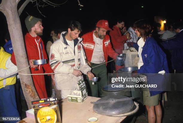 Les concurrents du rallye Paris-Dakar lors du repas du soir le 14 janvier 1986 au Mali.