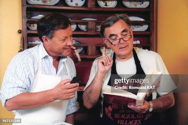 Le chef cuisinier Georges Blanc et le journaliste Bernard Pivot cuisinent à l'occasion de la sortie du livre du restaurateur, le 14 août 1999 dans sa...