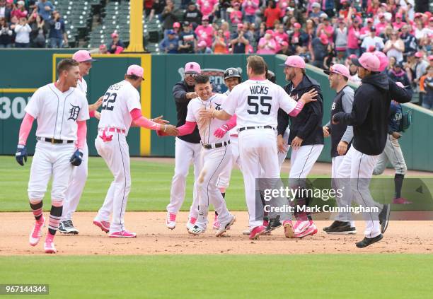 Teammates mob Jose Iglesias of the Detroit Tigers after he hit the game winning single during the Mother's Day game against the Seattle Mariners at...