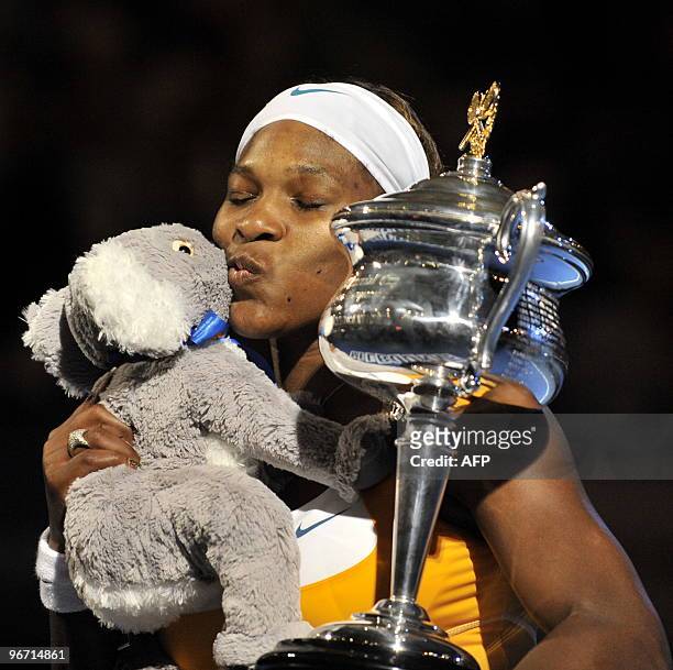 Tennis player Serena Williams poses with a koala soft toy and the trophy after victory in her women's singles final match against Belgian opponent...