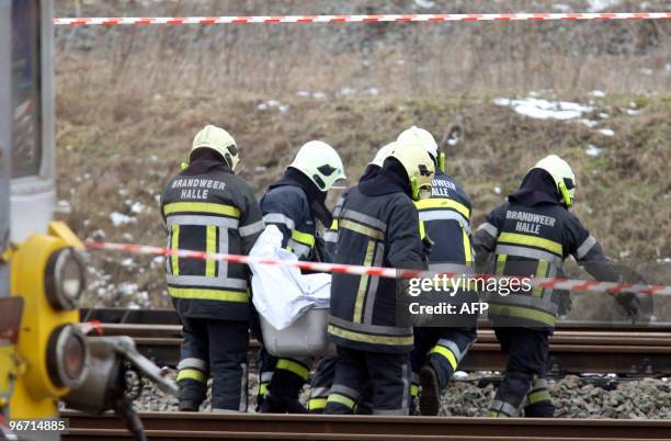 Firemen remove bodies of victims of the collision between two passengers trains on February 15 in Buizingen station, in Halle. Twelve people are...