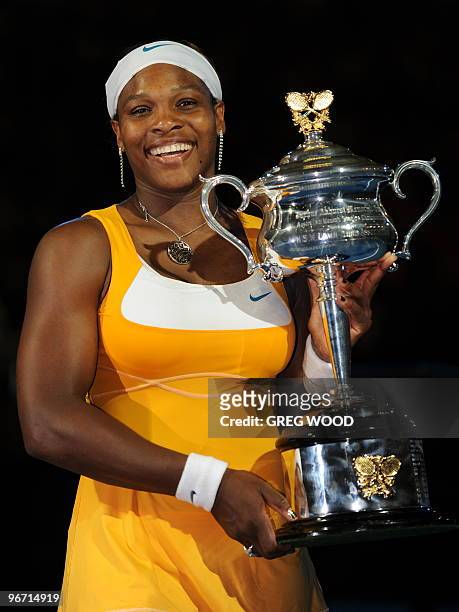 Serena Williams of the US poses with the trophy following her victory over Justine Henin of Belgium in their women's singles final match on day 13 of...