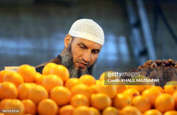 Man buys vegetables from a traditional market in downtown Amman on June 4, 2018. Jordan's King Abdullah has summoned the prime minister for a meeting...