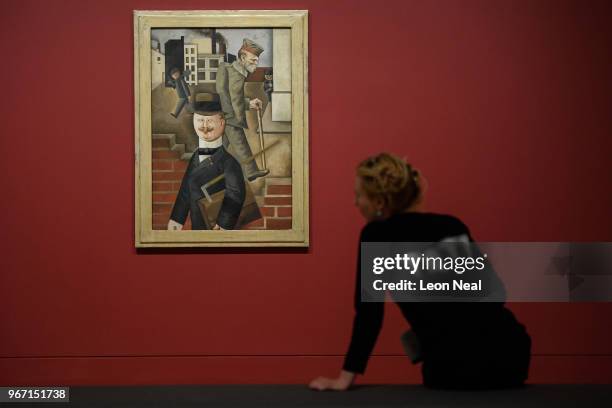 Gallery assistant poses with "Grey Day" by George Grosz at the "Aftermath: Art in the Wake of World War One" exhibition at Tate Britian on June 4,...
