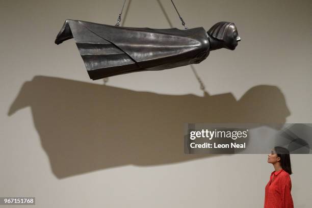 Gallery assitant poses with "The Floating One" by Ernst Barlach at the "Aftermath: Art in the Wake of World War One" exhibition at Tate Britian on...