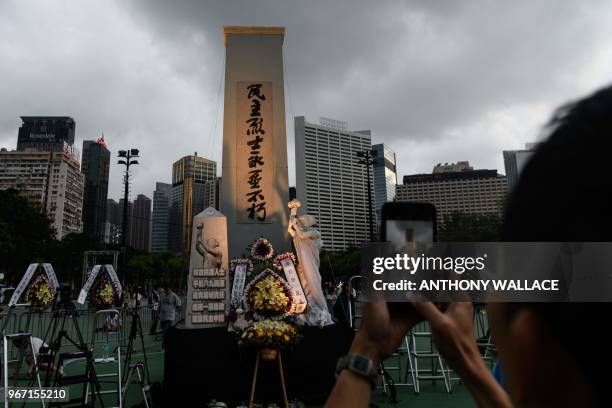 Man takes a photo of a statue depicting the Goddess of Democracy ahead of a candlelight vigil in Hong Kong on June 4, 2018 to mark the 29th...