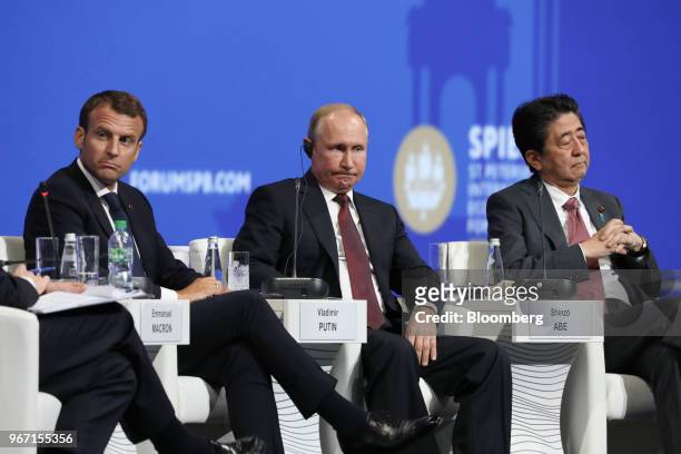 Vladimir Putin, Russia's president, center, Emmanuel Macron, France's president, left, and Shinzo Abe, Japan's prime minster, look on during the...