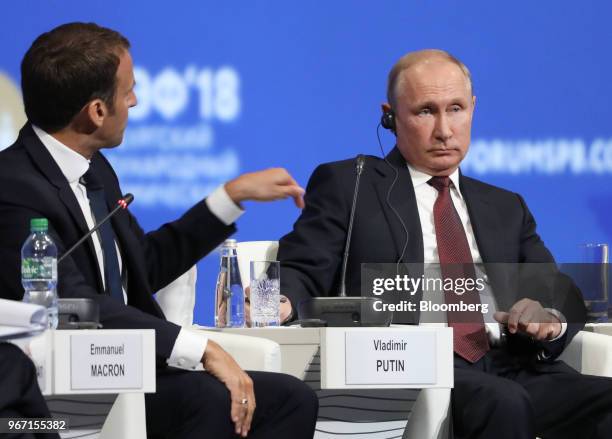 Vladimir Putin, Russia's president, right, looks on as Emmanuel Macron, France's president, speaks during the plenary session at the St. Petersburg...