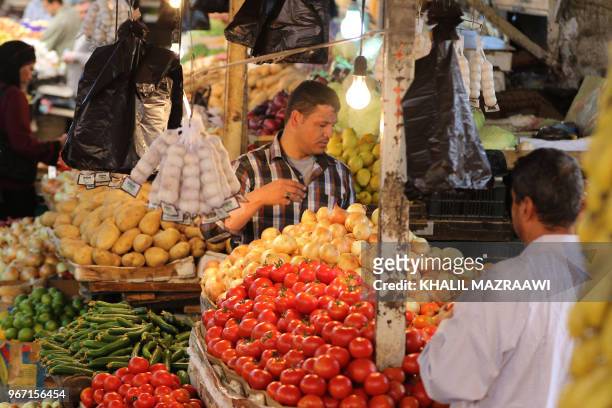 People buy fruits and vegetable at a market in downtown Amman on June 4 , 2018. Jordan's King Abdullah has summoned the prime minister for a meeting...