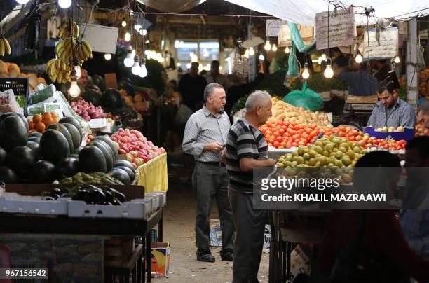 People buy fruits and vegetable at a market in downtown Amman, Jordan on June 4 , 2018. Jordan's King Abdullah has summoned the prime minister for a...