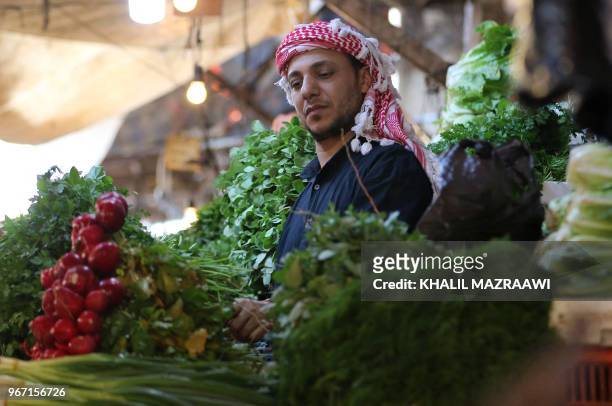 Vendor sells vegetable at a market in downtown Amman on June 4 , 2018. Jordan's King Abdullah has summoned the prime minister for a meeting that...