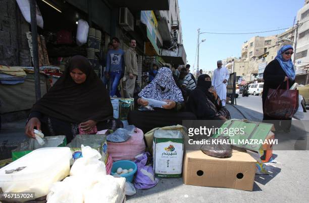 Women sell homemade white cheese and eggs in downtown Amman on June 4 , 2018. Jordan's King Abdullah has summoned the prime minister for a meeting...