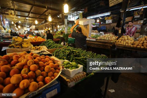 Vendors sell vegetable and fruits at a market in downtown Amman on June 4 , 2018. Jordan's King Abdullah has summoned the prime minister for a...