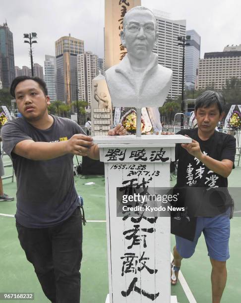 Men carry a bust of deceased pro-democracy activist Liu Xiaobo for an event in Hong Kong's Victoria Park on June 4 to mark the 29th anniversary of...