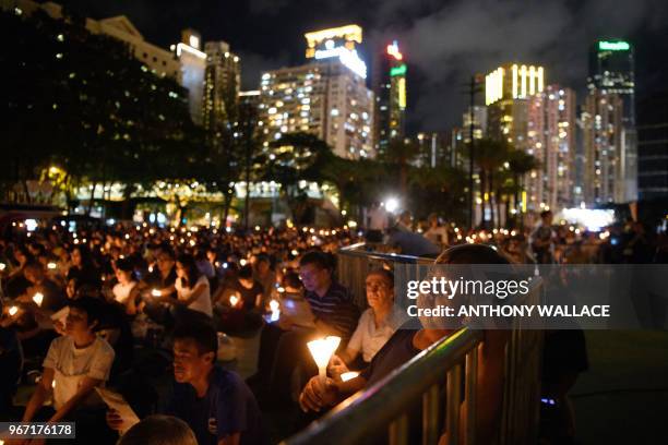 People hold candles during a vigil in Hong Kong on June 4 to mark the 29th anniversary of the 1989 Tiananmen crackdown in Beijing. - Crowds assembled...