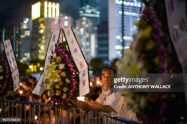 Man holds a candle during a vigil in Hong Kong on June 4 to mark the 29th anniversary of the 1989 Tiananmen crackdown in Beijing. - Crowds assembled...