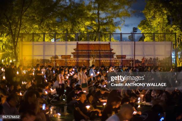 People hold candles in front of a backdrop showing Beijing's Tiananmen Square during a vigil in Hong Kong on June 4 to mark the 29th anniversary of...