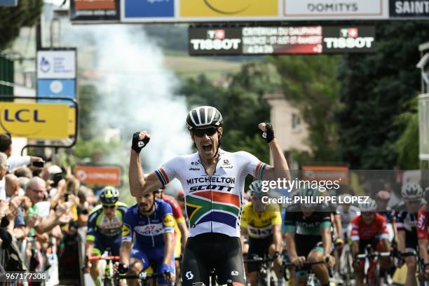 South Africa's Daryl Impey celebrates as he crosses the finish line to win the first stage of the 70th edition of the Criterium du Dauphine cycling...