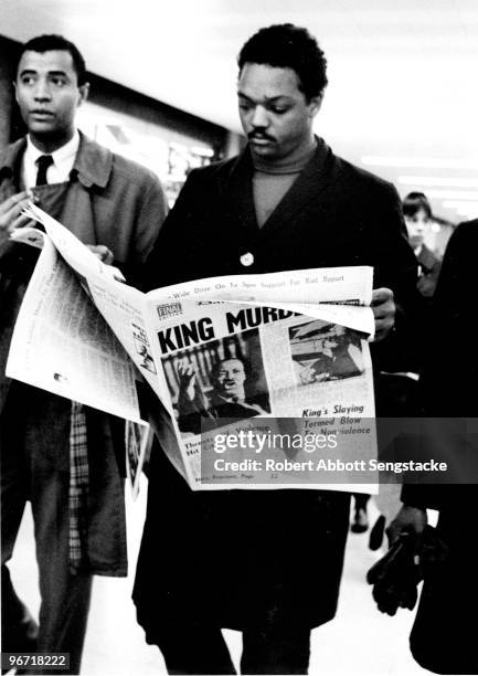 As he walks through O'Hare Airport, American Civil Righter leader and minister Jesse Jackson holds a copy of the Chicago Daily Defender newspaper,...