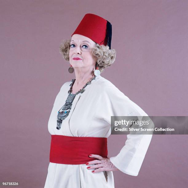 American actress Bette Davis wearing a fez, circa 1970.