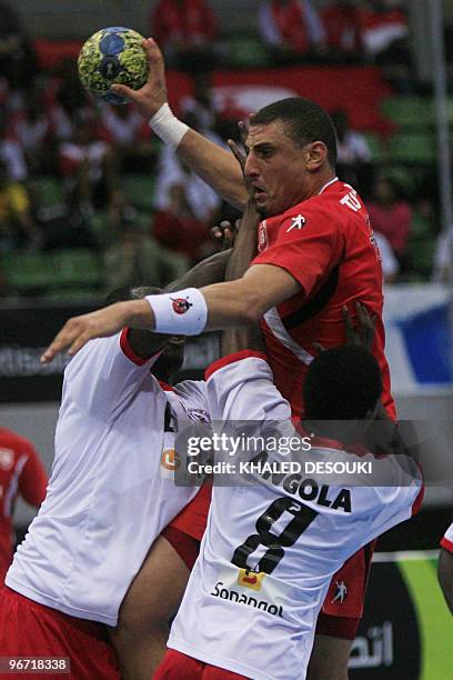 Hamam Wissen of Tunis is challenged by Teca Fernando and Kamuanga Belchik of Angola during their quarter-final match in 19th Africa Nations Handball...