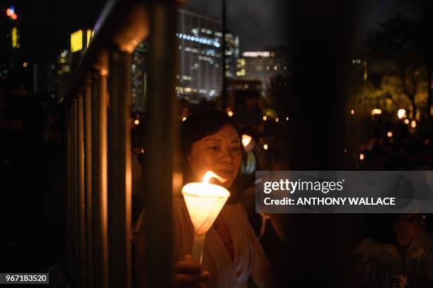 Woman holds a candle during a vigil in Hong Kong on June 4 to mark the 29th anniversary of the 1989 Tiananmen crackdown in Beijing. - Crowds...