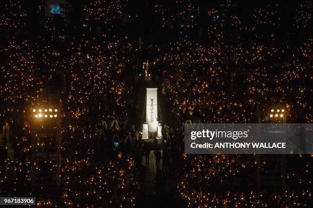 People hold candles during a vigil in Hong Kong on June 4 to mark the 29th anniversary of the 1989 Tiananmen crackdown in Beijing. - Crowds assembled...