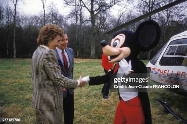 Edith Cresson, ministre du Commerce extérieur, serre la main à Mickey, le personnage de Walt Disney à coté de Michel Giraud le 19 décembre 1985 en...