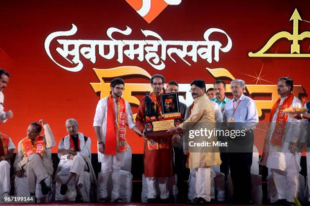 Shiv Sena President Uddhav Thackeray with son Aditya Thackeray during event commemorating 50th anniversary of Shiv Sena on June 19, 2016 in Mumbai,...