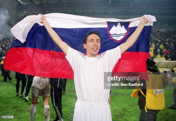 Zoran Pavlovic of Slovenia celebrates with the National Flag after the 2002 World Cup Play-off Second Leg match against Romania played at the Steaua...