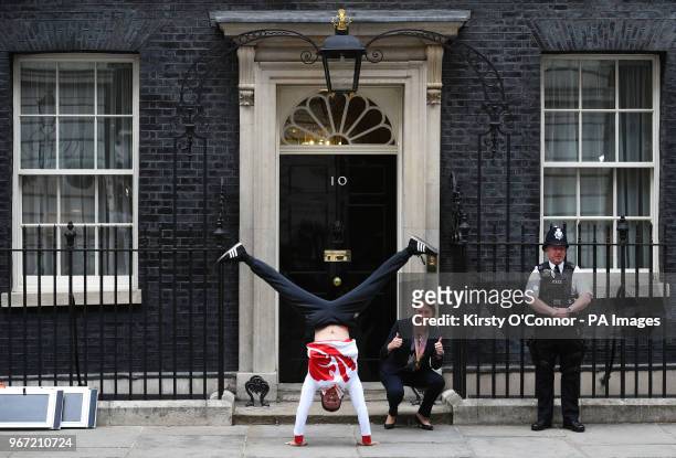 Gymnast Dominick Cunningham performs a hand stand on the steps of 10 Downing Street, London, with Sports Minister Tracey Crouch.