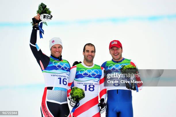 Aksel Lund Svindal of Norway, Didier Defago of Switzerland and Bode Miller of the United States celebrate after the Alpine skiing Men's Downhill at...