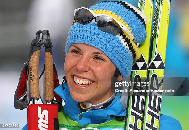 Charlotte Kalla of Sweden smiles after winning the gold during the flower ceremony for the women's cross-country skiing 10 km final on day 4 of the...