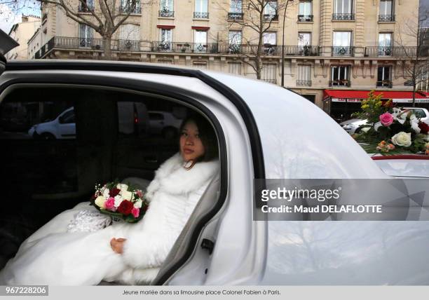Jeune mariée dans une limousine place Colonel Fabien à Paris, France.