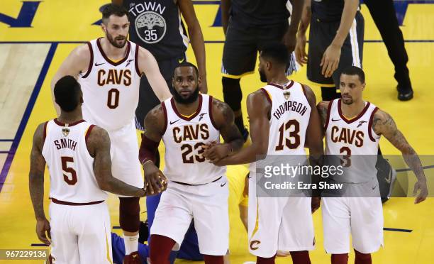LeBron James is helped ot his feet by JR Smith and Tristan Thompson of the Cleveland Cavaliers in Game 2 of the 2018 NBA Finals against the Golden...