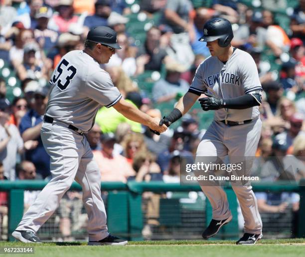 Austin Romine of the New York Yankees is congratulated by third base coach Phil Nevin after hitting a three-run home run against the Detroit Tigers...