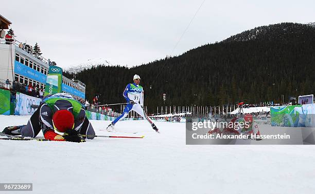 Dario Cologna of Switzerland falls over the line in the men's cross-country skiing 15 km final on day 4 of the 2010 Winter Olympics at Whistler...