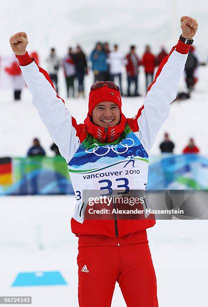 Dario Cologna of Switzerland celebrates winning gold during the flower ceremony for the Cross-Country Skiing Men's 15 km Free on day 4 of the 2010...