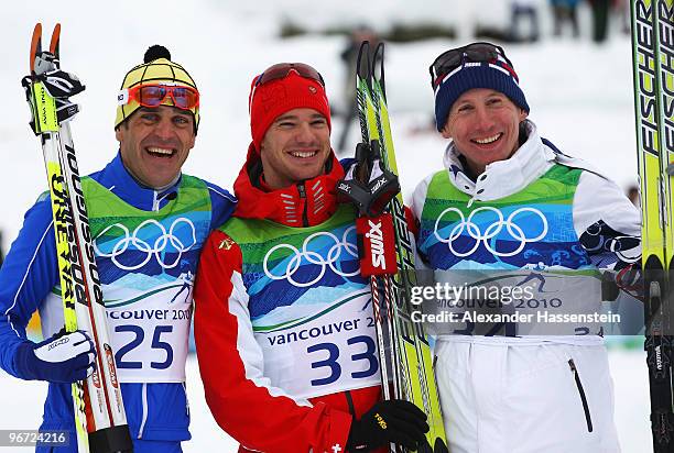 Pietro Piller Cottrer of Italy celebrates winning silver, Dario Cologna of Switzerland gold and Lukas Bauer of Czech Republic bronze during the...