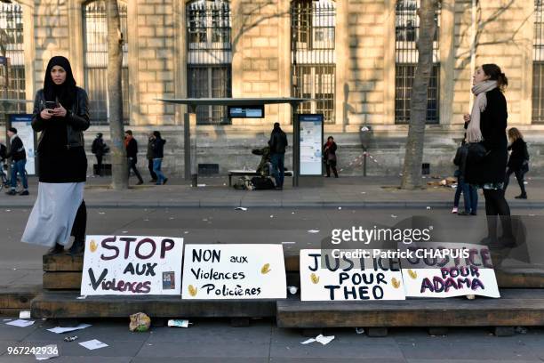 Pancartes disposées sur le trottoir entre deux jeunes femmes, lors d'un rassemblement contre les violences policières, le 16 février 2016, place de...