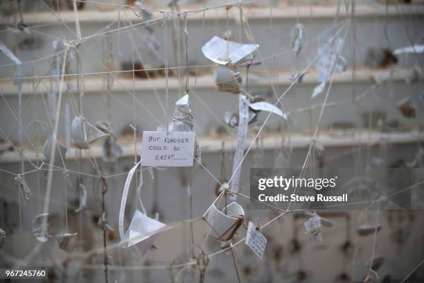 Line and Mend Pieces create a web on string on the walls and about four feet off the ground. The lines are the string that hangs with pieces of cups...