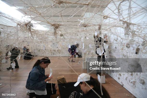 Line and Mend Pieces create a web on string on the walls and about four feet off the ground. The lines are the string that hangs with pieces of cups...