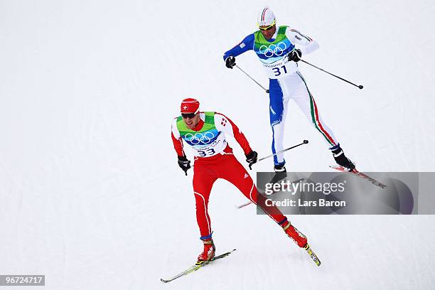 Dario Cologna of Switzerland and Giorgio Di Centa of Italy compete during the Cross-Country Skiing Men's 15 km Free on day 4 of the 2010 Winter...