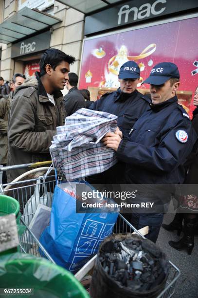 Des policiers controlent un vendeur à la sauvette sur le boulevard Haussmann le 19 décembre 2008 à Paris, France.