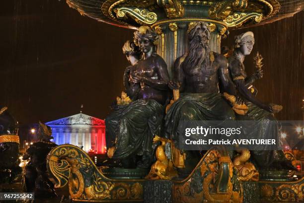 Fontaine des mers sur la place de la Concorde et en arrière plan l'Assemblée Nationale illuminée de bleu, blanc et rouge après les attentats de...