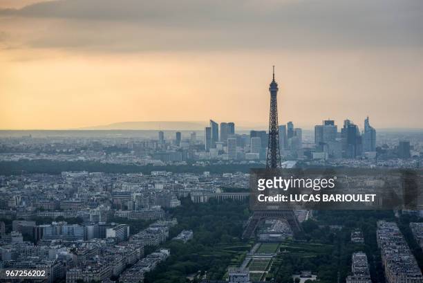 Picture taken on June 4, 2018 from the observatory deck of the Montparnasse tower in Paris, shows a view the Eiffel tower and the Defense business...
