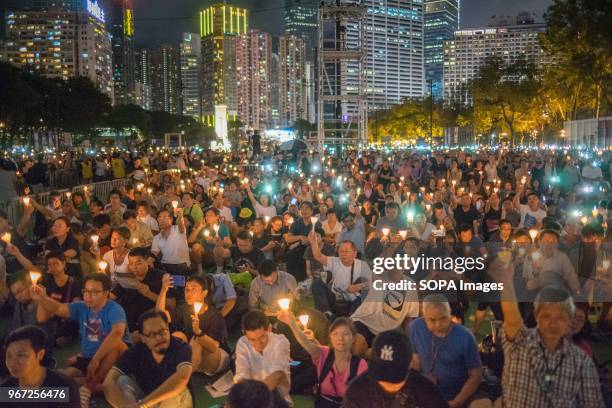 People seen holding candles during the vigil service. Hundreds of thousands of Hong Kong people attended the annual candlelight vigil service in...