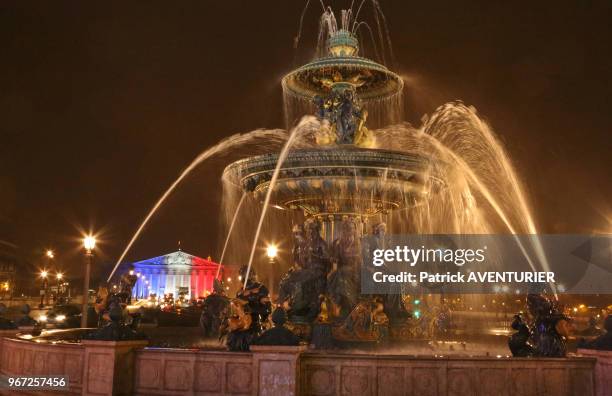 Fontaine des mers sur la place de la Concorde et en arrière plan l'Assemblée Nationale illuminée de bleu, blanc et rouge après les attentats de...